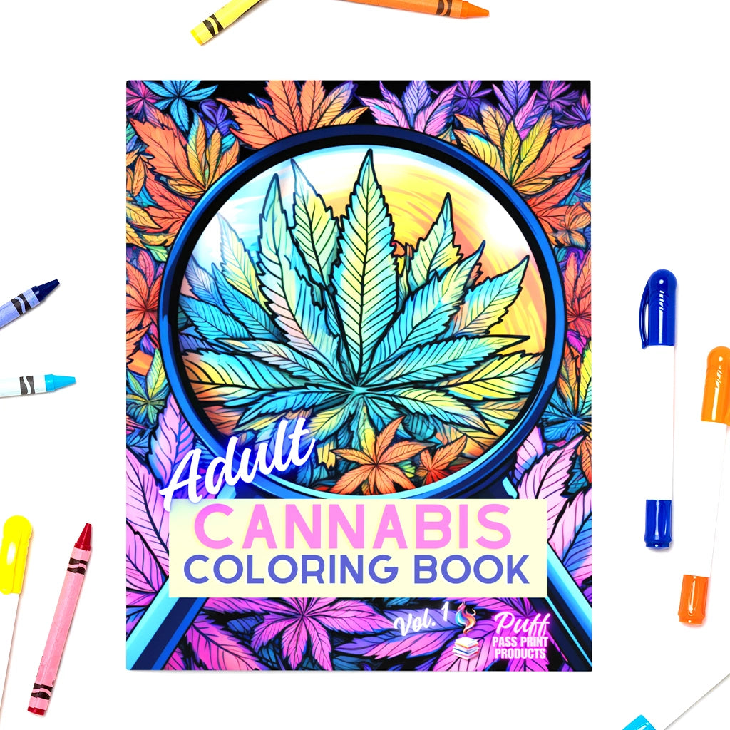 A vibrant and colorful cover of the Puff Pass Print Adult Cannabis Coloring Book, featuring an intricately designed cannabis leaf surrounded by other colorful leaves. Crayons and markers are arranged around the book, highlighting its creative and artistic appeal.