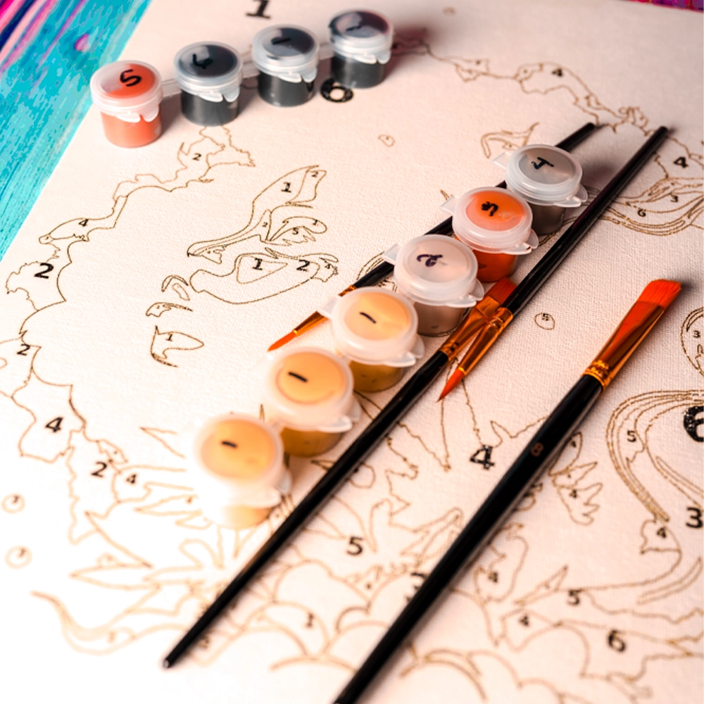 A close-up view of the Puff Pass Print Watercolor Paint by Numbers Cannabis Painting Kit. The image shows a pre-printed numbered canvas along with labeled paint pots and three paintbrushes arranged neatly. The canvas features detailed outlines with numbers corresponding to the colors in the paint pots. The vibrant background enhances the artistic appeal of the kit.